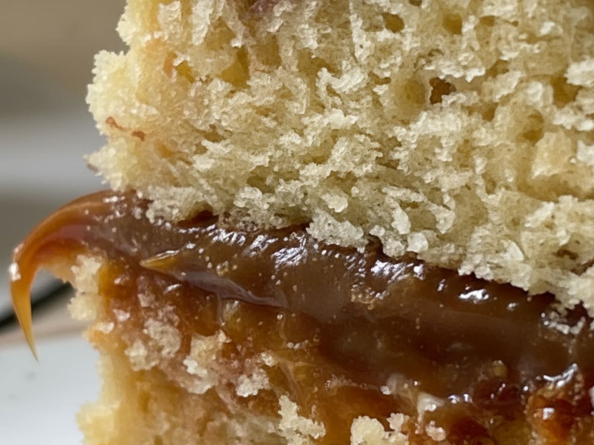 Corte de torta mostrando capas de bizcocho con relleno de arequipe